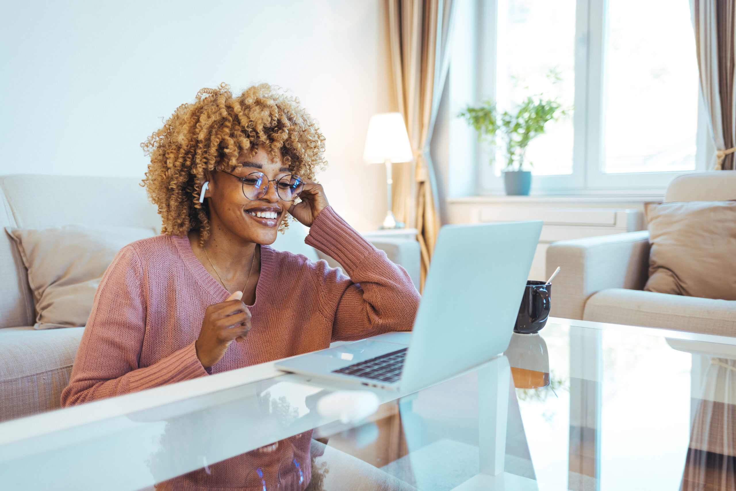 African American woman smiling whilst looking at her laptop on a money date